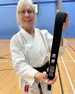 Sue holding her new karate blackbelt