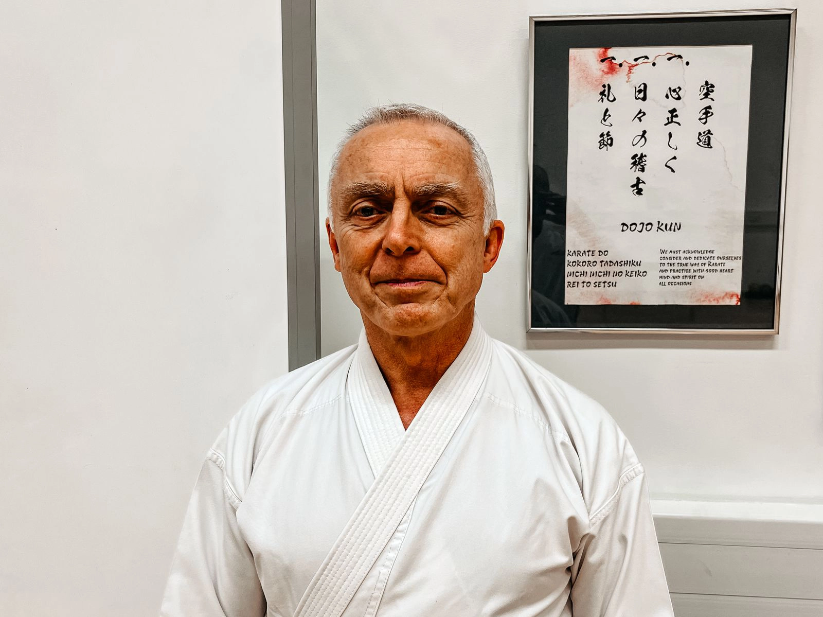 Nick Sensei proudly stands in front of the Dojo Kun at SKIF Devon